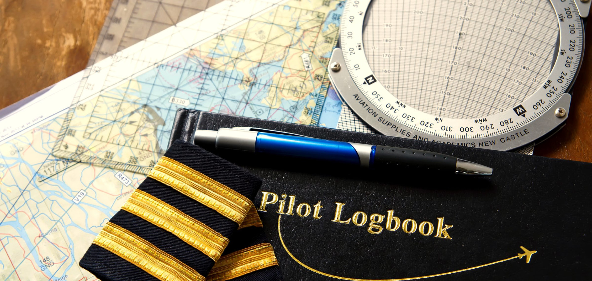 Pilóta napló, navigációs térkép és iránytű egy asztalon